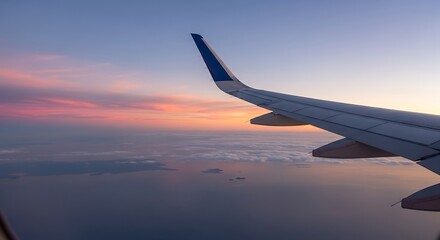 Obraz premium Airplane wing soaring through the colorful sunset sky.
