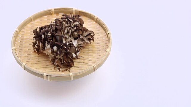手で二つに割られる大きな黒舞茸の動作
