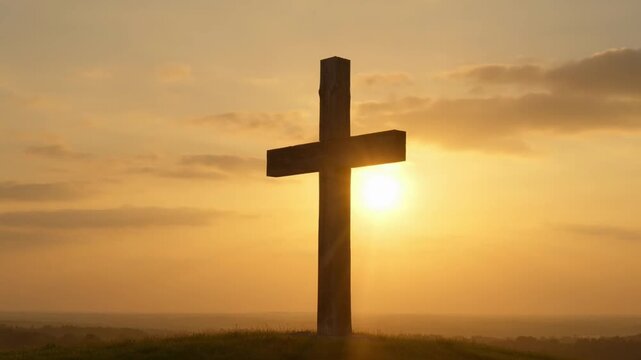 A dramatic golden cross stands silhouetted against a serene sunrise sky, evoking spiritual hope.