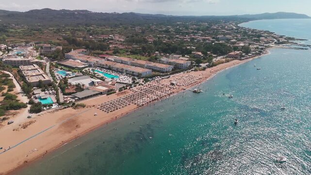 Aerial Pan Out of Issos Beach Resort and Sun Loungers by the Ionian Sea in Corfu