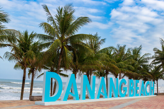 Da Nang, Vietnam - January 12, 2026: Travel signpost of Danang beach located on the My Khe beach promenade against palm trees, sea and blue sky background in Da Nang, Vietnam