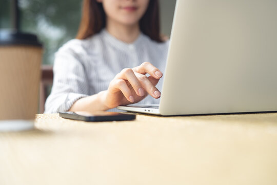 Woman remote working using laptop at outdoor cafe or modern workspace, digital nomad lifestyle, work from anywhere