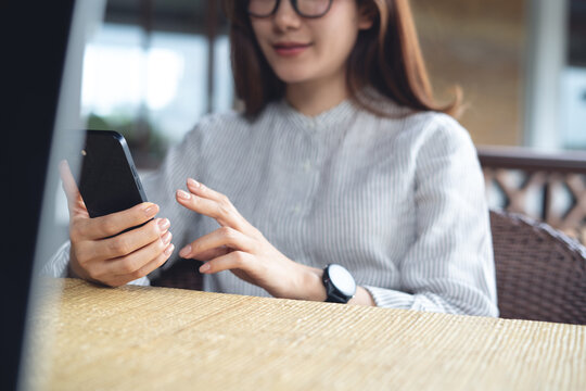 Smiling young asian woman using smartphone for social network, surfing the net at home, close up