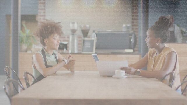Left woman lifting wrist, showing device for business; listener reading paper, UI marking wrist