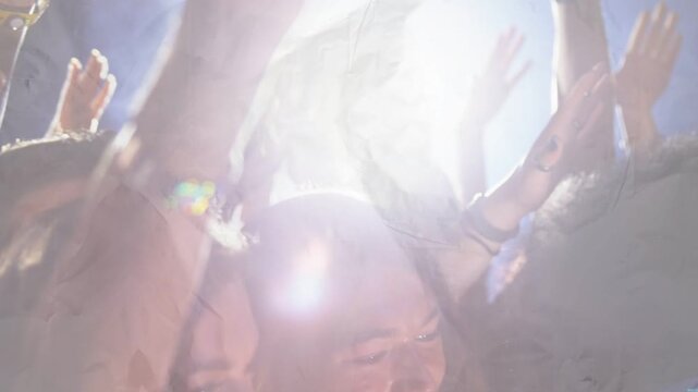 Vertical video: Audience raising hands and phones, reacting to flaring backlight during live event