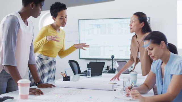 Four women designers starting plan review, yellow speaker gesturing, animated cues aligning plans