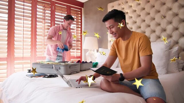 2 men packing trip suitcase one holding blue shirt other checking passport typing laptop gold-stars