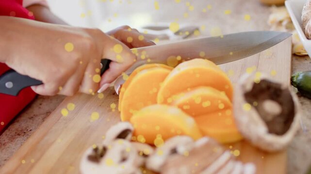Cook's hands making knife cut, slicing veg stack on board, yellow confetti across hands for recipe