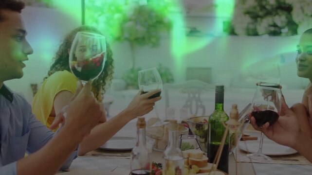 Four friends at toast lifting wine glasses in dining scene, green overlay partially obscuring faces