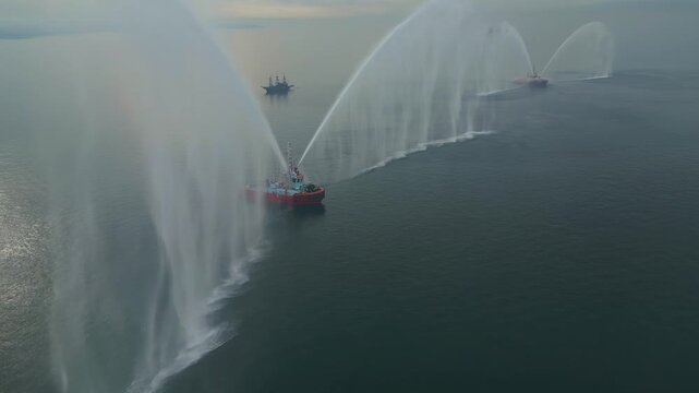 THESSALONIKI, GREECE - JANUARY 6, 2024 Cinematic aerial drone shot orbiting fireboats spraying massive water arches in the Thermaikos Gulf during the morning Epiphany celebrations.