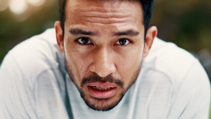 Fototapeta premium Man, sweat and portrait for fitness at park, serious and exhausted with fatigue on break. Person, runner and outdoor with nature for exercise, cardio challenge and burnout for wellness in Cambodia