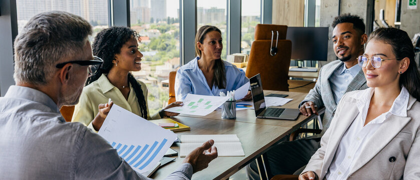 City skyline visible as executives examine fiscal reports carefully