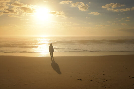 Side view young girl walking with shadow sunrise Cape Hatteras N