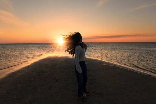 Teen girl beautiful long hair spinning at sunset Pamlico Sound O