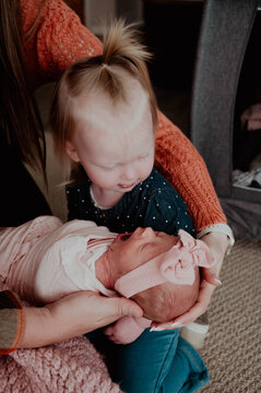 Big sister holding newborn baby sister