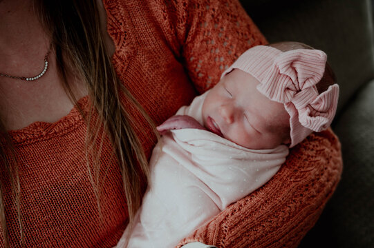 Close-up of newborn baby in moms arms