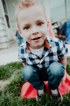 Close-up of toddler boy outside on small slide