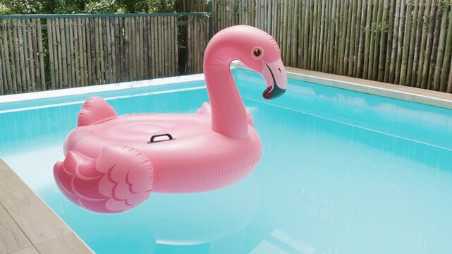 A pink inflatable flamingo pool float floating in a swimming pool