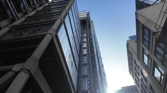 Financial district of london with iconic modern architecture, representing uk's economy, global business, and corporate power, with glass elevators moving up a skyscraper