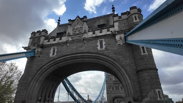 Iconic tower bridge in london featuring its famous bascule and suspension design, a symbol of the city's history, economy, and financial district on a cloudy day