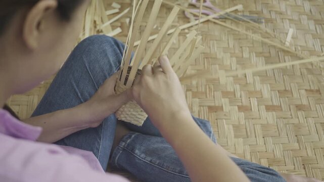 Explore the art of weaving with natural materials. This image depicts skilled hands creating intricate designs, showcasing the beauty of traditional crafting techniques.