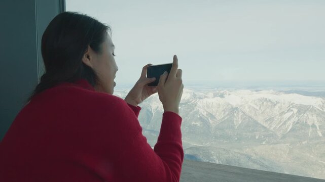 A person enjoying a breathtaking view of snow-capped mountains from a high vantage point, capturing the beauty of nature.