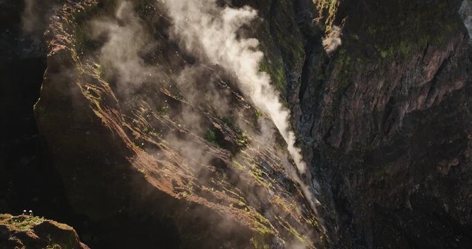 Ambrym Island's Benbow and Marum volcano crater rim showing a column of steam and gas rising from the deep caldera, highlighting the raw power and geological activity of the stratovolcano