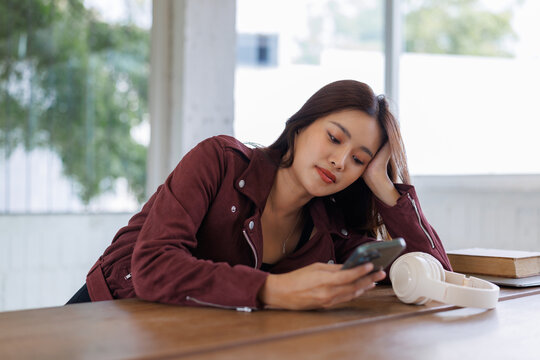 Young woman using smartphone feeling bored or tired