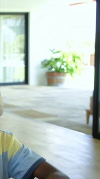 Vertical video: Laptop pinging boy with headset, reaching, leaving, showing home patio, copy space