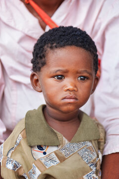 Young african Child in Rural Botswana in the Kalahari Desert held by his mother