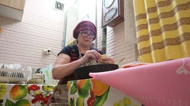 Elderly Woman Preparing Traditional Homemade Dumplings in a Rustic Domestic Kitchen Setting