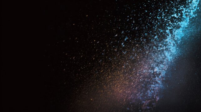 Bright colorful water fountain illuminated against deep dark background, droplets frozen in motion, strong contrast, side composition, minimal scene