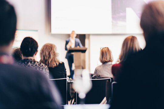 Speaker giving a talk in conference hall at business event. Rear view of unrecognizable people in audience at the conference hall. Business and entrepreneurship concept