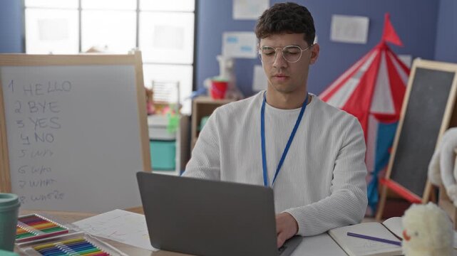 Man teacher gesturing with hands by laptop and whiteboard, then stretching hands behind head in classroom building; relaxed learning focus.