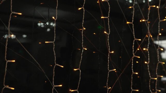 Bright lights are strung up in a dark area, creating a warm glow for an event. The setup shows multiple strings of lights hanging down.