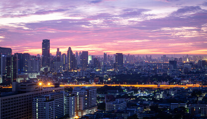 Obraz premium BANGKOK, THAILAND - MAY 15, 2015: A breathtaking sunrise view over the Bangkok skyline, featuring a vibrant purple and orange sky during twilight.