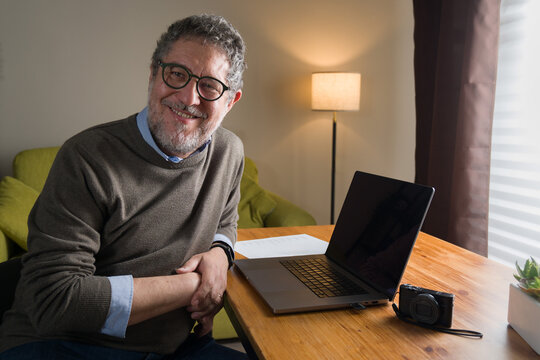 Senior man working on laptop at home office smiling confident creative professional