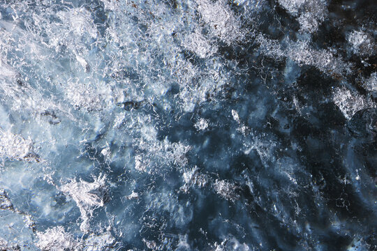 View of the crystalline blue ice of Svinafellsjokull glacier with intricate cracks and frozen air bubbles Sveitarfelagid Hornafjordur, Iceland.