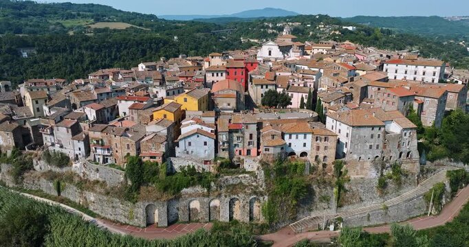 Panoramic drone view Orte Italy cityscape. Medieval town stone rooftops green valley forest sunny day. Italian tourism destination urban landscape Lazio holiday travel exploration landscape nature.
