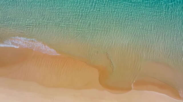 Aerial view of tranquil beach with gentle waves lapping at the shore. Ideal for relaxation, vacation planning, and coastal imagery