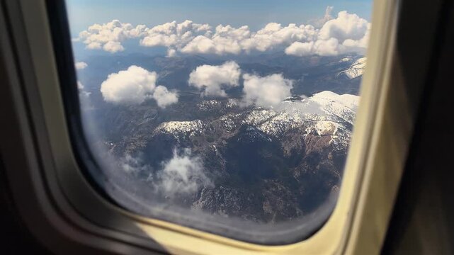 Flight Above Clouds Over Snowy Mountains Before Landing in Dalaman, View From Airplane Window