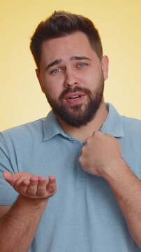Need some more, please give me. Caucasian man showing a little bit gesture with sceptic smile, showing minimum sign, measuring small size. Handsome boy isolated alone on yellow studio background