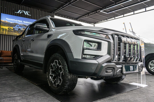 Silver pickup with black wheels showcased indoors under bright lights