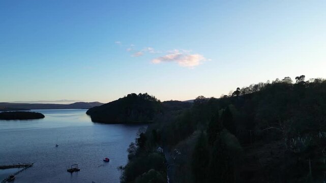 Aerial View of Calm Water of Massive Lake at Balmaha Valley Village Near Glasgow Landscape During Sunset. Village is a popular tourist destination for picnickers and day trippers from Glasgow