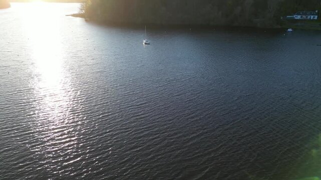 Aerial View of Calm Water of Massive Lake at Balmaha Valley Village Near Glasgow Landscape During Sunset. Village is a popular tourist destination for picnickers and day trippers from Glasgow