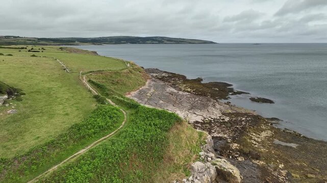 Aerial View of Coastal Footpath Along Rocky Shoreline in Anglesey Wales