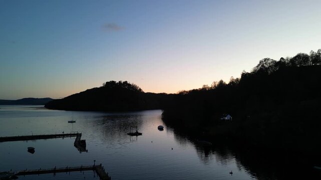 Aerial View of Calm Water of Massive Lake at Balmaha Valley Village Near Glasgow Landscape During Sunset. Village is a popular tourist destination for picnickers and day trippers from Glasgow