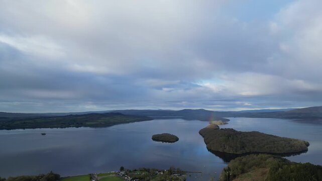 Aerial View of Calm Water of Massive Lake at Balmaha Valley Village Near Glasgow Landscape During Sunset. Village is a popular tourist destination for picnickers and day trippers from Glasgow