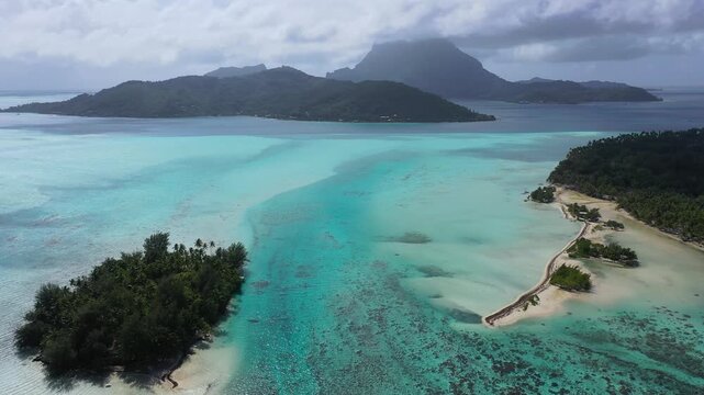 An aerial view of Blue Heaven Island in Bora Bora, French Polynesia, showcasing turquoise ocean waters, white sandy beaches and lush tropical greenery