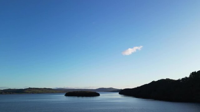 Aerial View of Calm Water of Massive Lake at Balmaha Valley Village Near Glasgow Landscape During Sunset. Village is a popular tourist destination for picnickers and day trippers from Glasgow